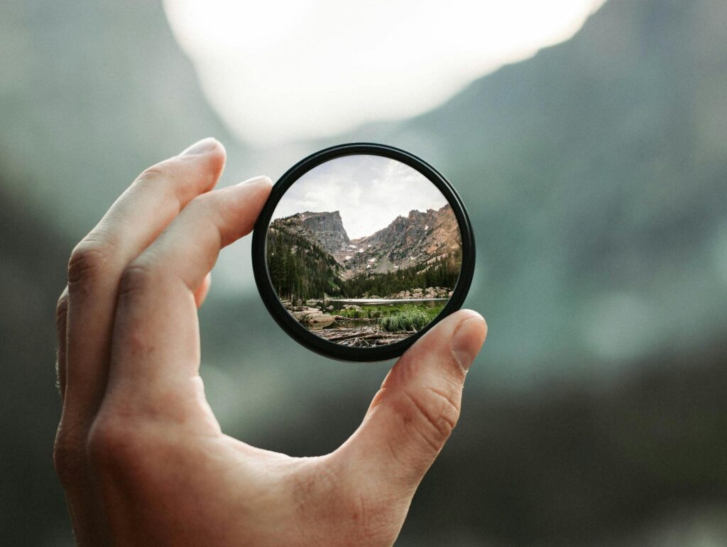 A stunning mountain landscape magnified through a handheld lens highlighting exploration and adventure.